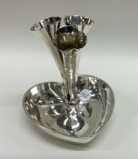 A decorative silver heart shaped three trumpet epe