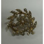 An 18 carat pearl swirl brooch with central flower