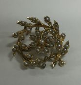 An 18 carat pearl swirl brooch with central flower