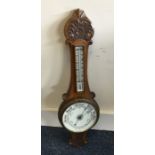 An Edwardian oak barometer. Est. £25 - £35.