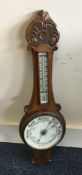 An Edwardian oak barometer. Est. £25 - £35.