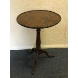 An Antique circular oak pedestal table on three sw