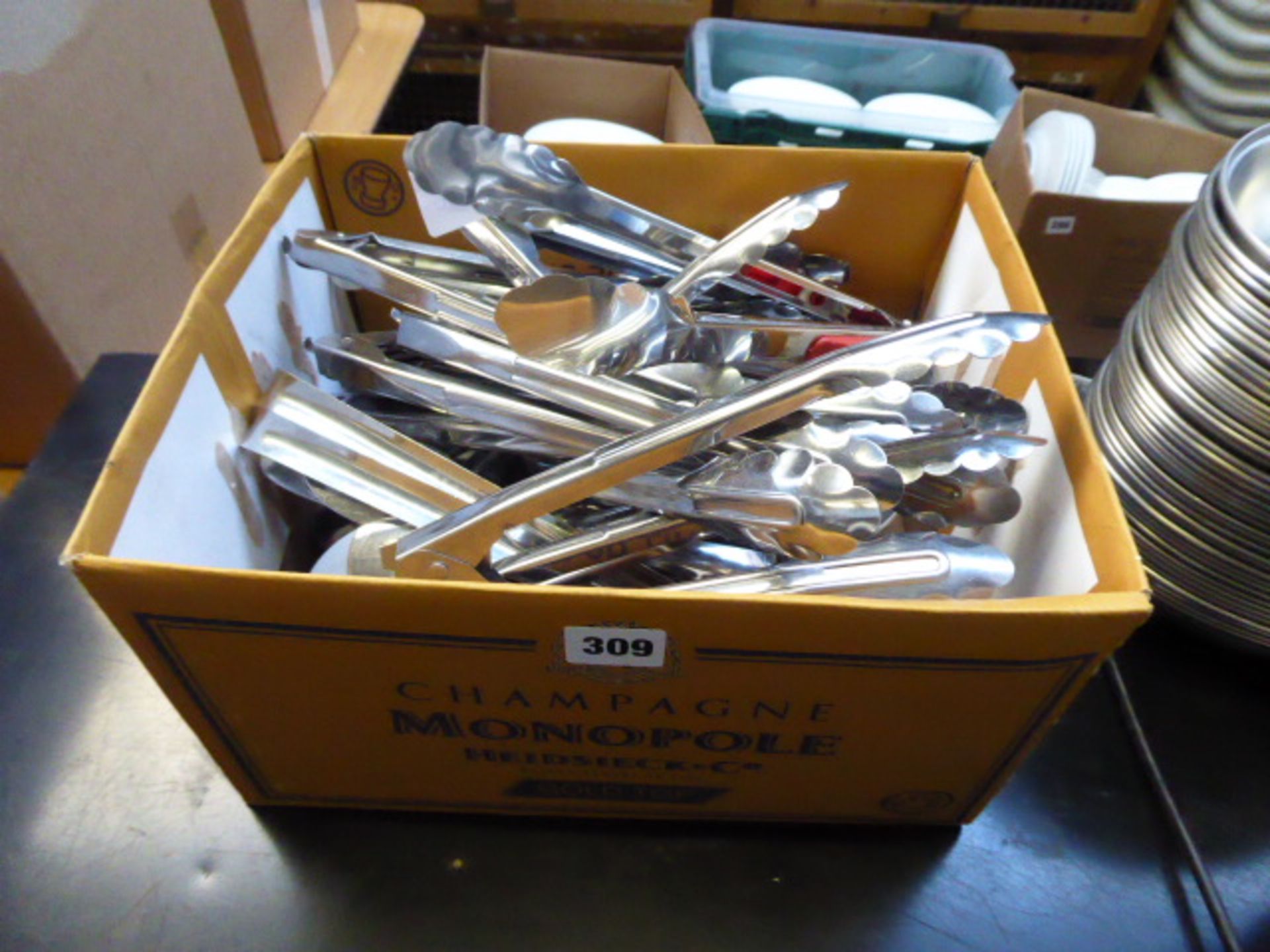 Box of assorted serving tongs and utensils