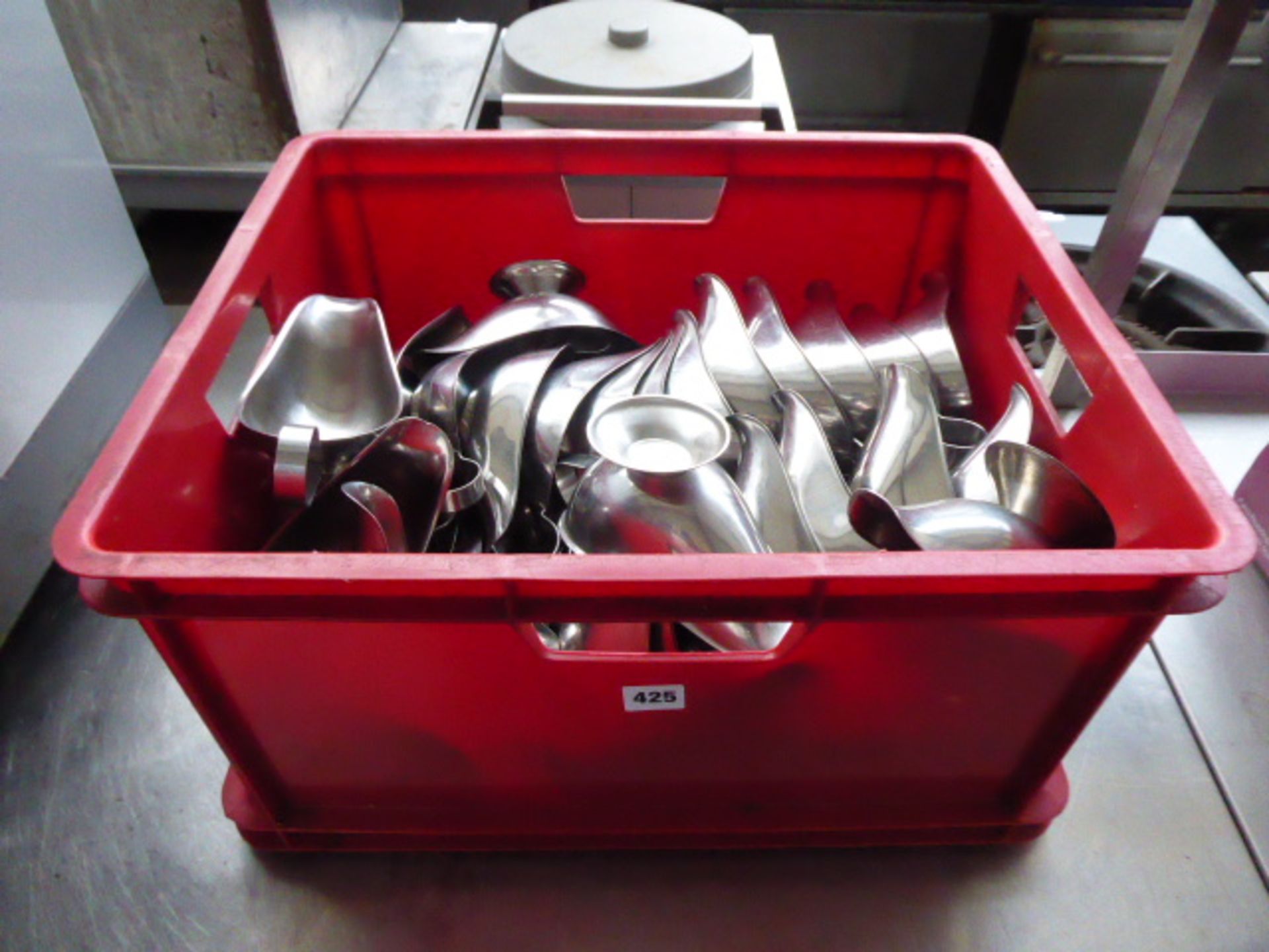 Large red crate containing stainless steel gravy boats