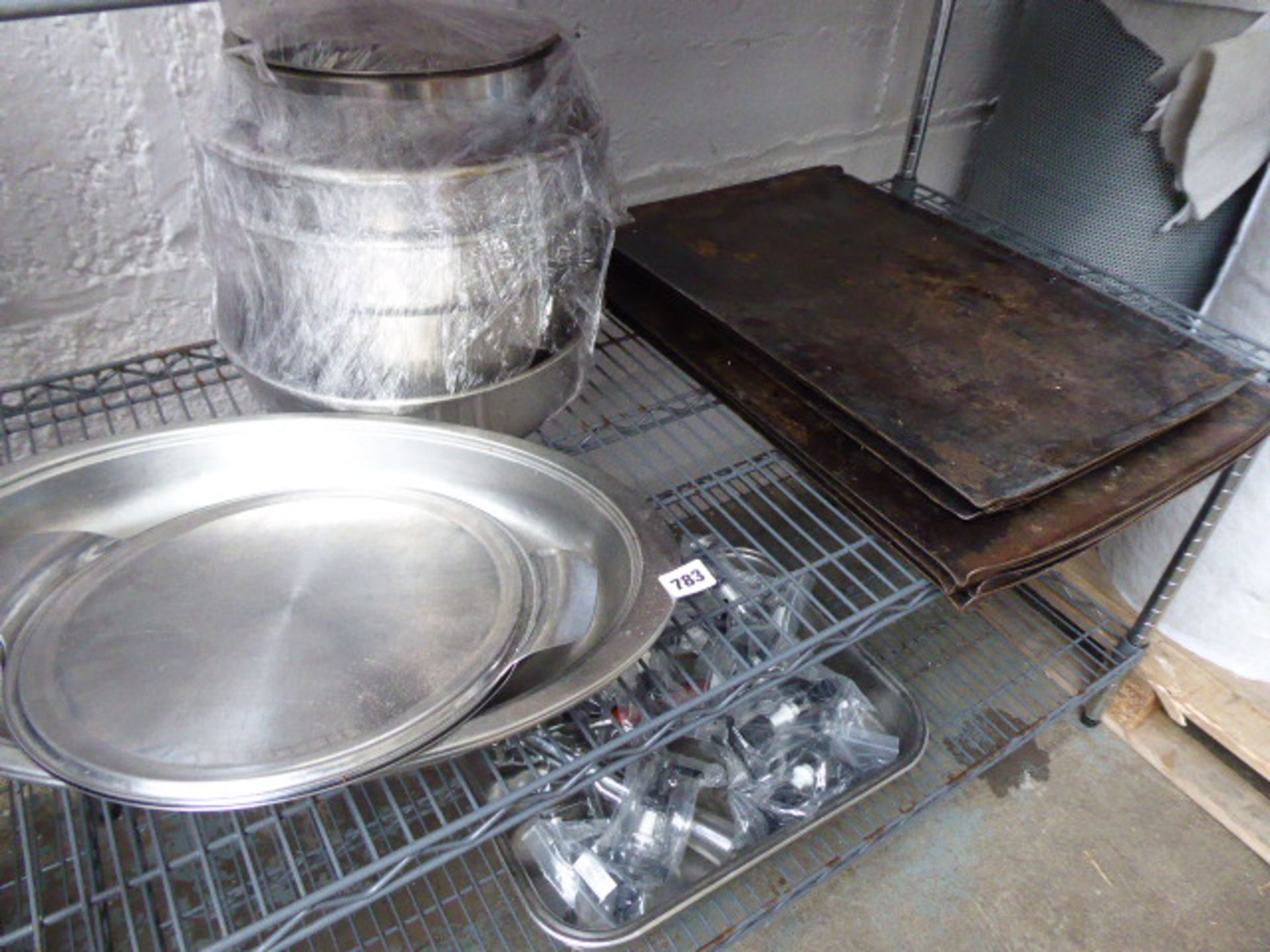 Shelf of baking trays, serving platters, and mixing bowls