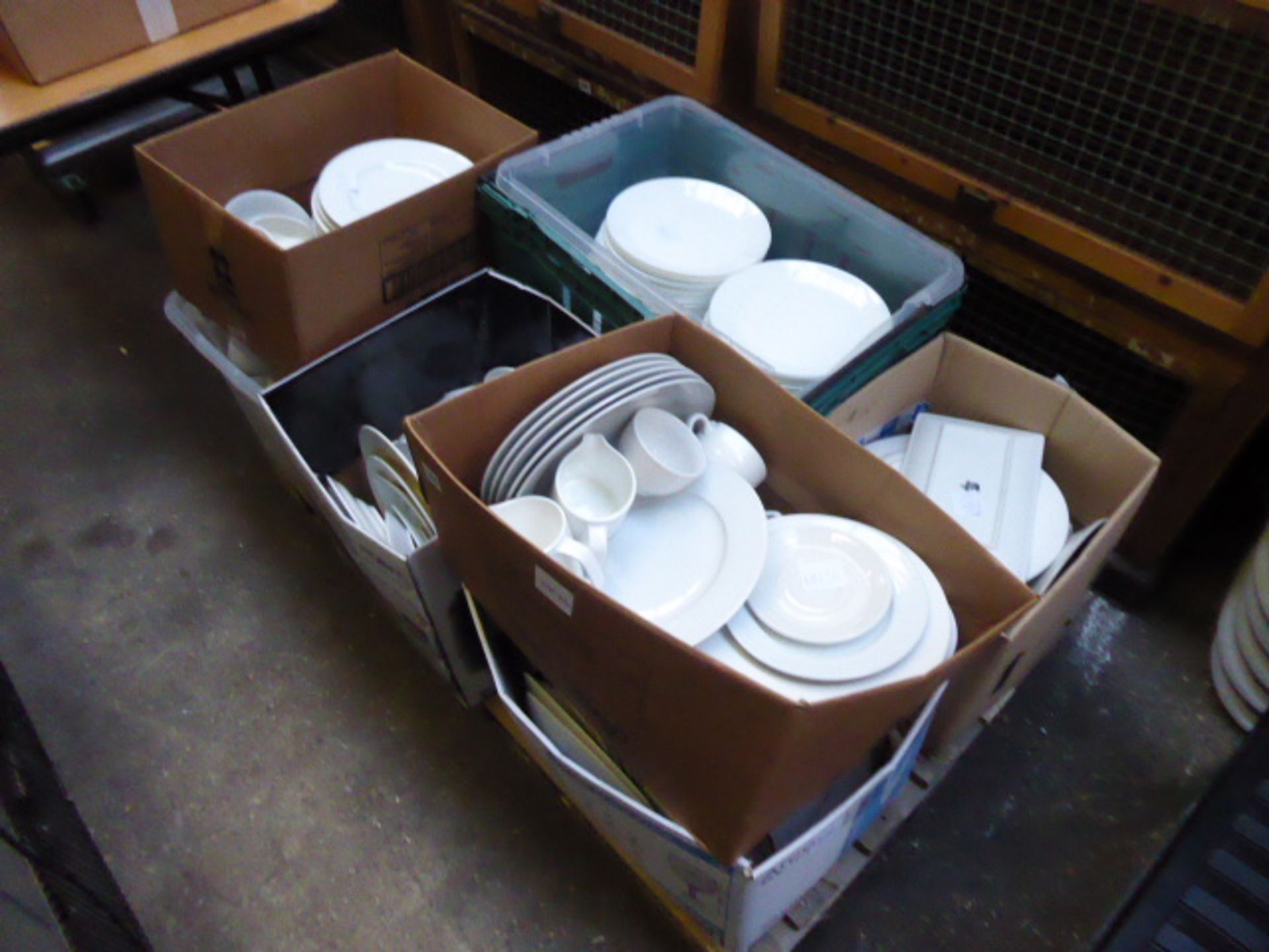 A pallet with 8 boxes of assorted white crockery including plates, cups, saucers, milk jugs etc