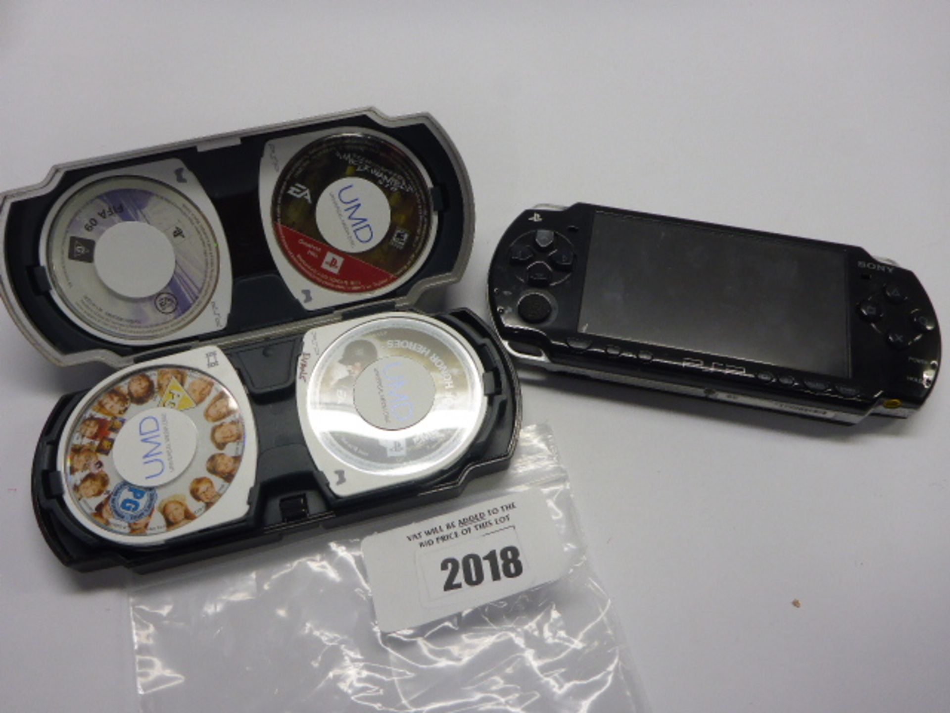 Sony PSP handheld console with various games and umd videos in case.