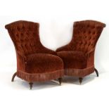 A pair of Victorian button upholstered armchairs with shaped back and mahogany feet on castors