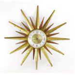 A 1970's teak and hammered brass 'Sunburst' or 'Starburst' wall clock by Paico, d.