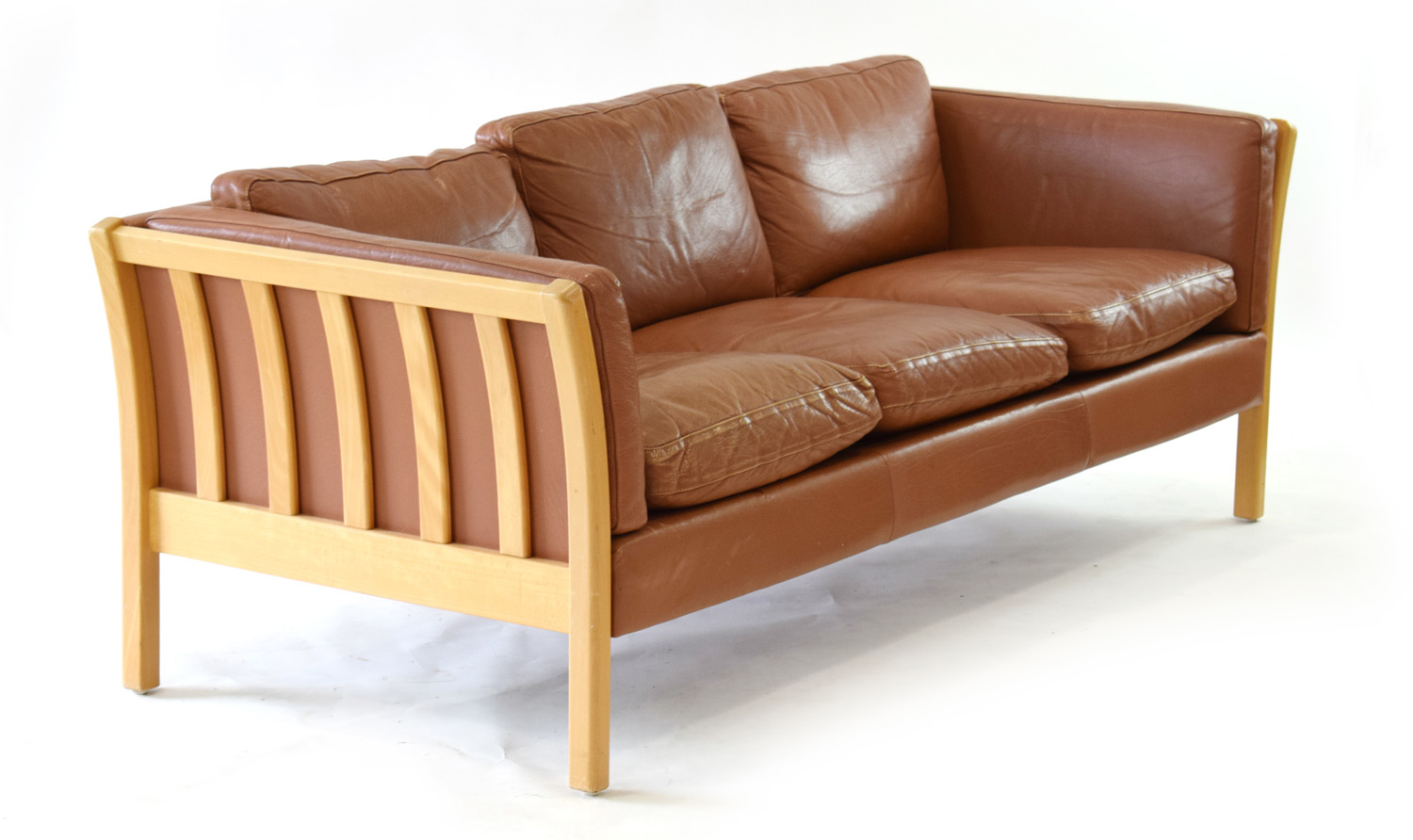 A Danish tan leather three seater sofa with an exposed beech frame, by Stouby, l.
