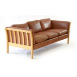 A Danish tan leather three seater sofa with an exposed beech frame, by Stouby, l.