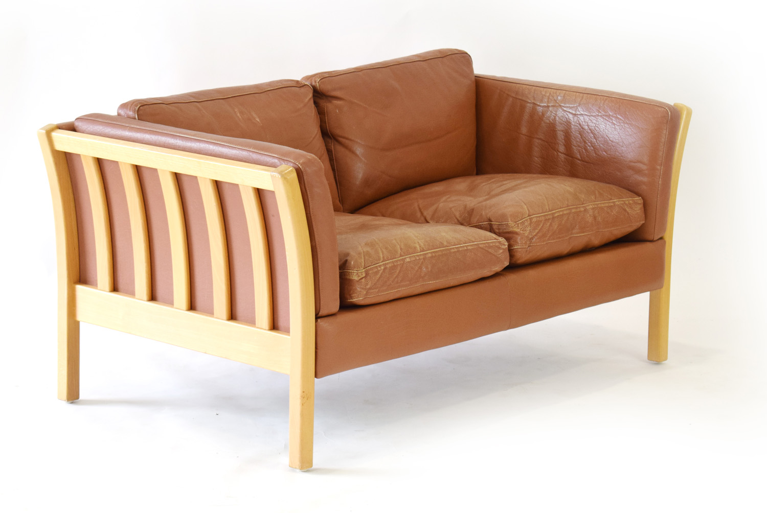 A Danish tan leather two seater sofa with an exposed beech frame,