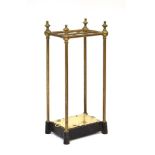 A late 19th/early 20th century brass six-section stick stand with a black and white cast iron base,