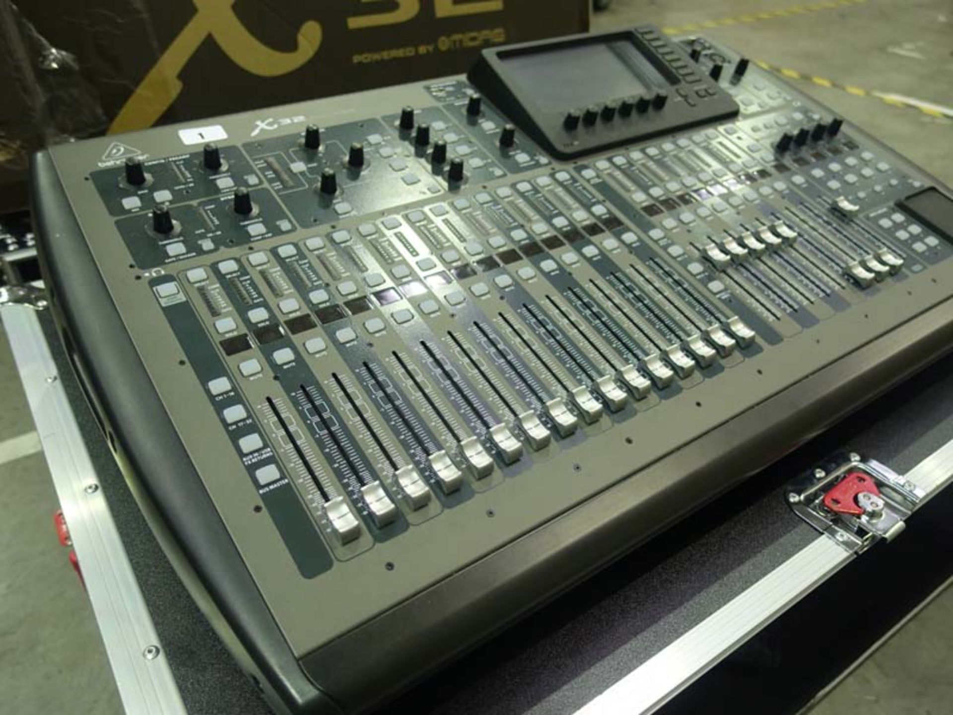 A Behringer Midas X32 32 channel digital mixing console with box and padded wheeled flight case