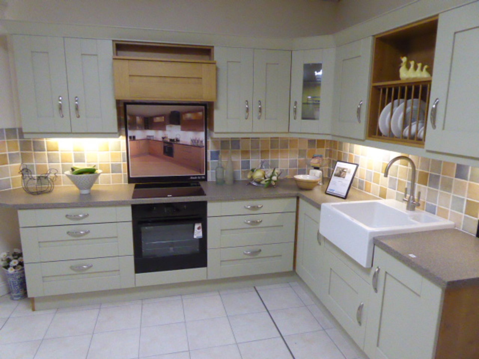 Milbourne Sage kitchen in L-shape with a granite effect worktop. Max dimension 330cm by 220cm.