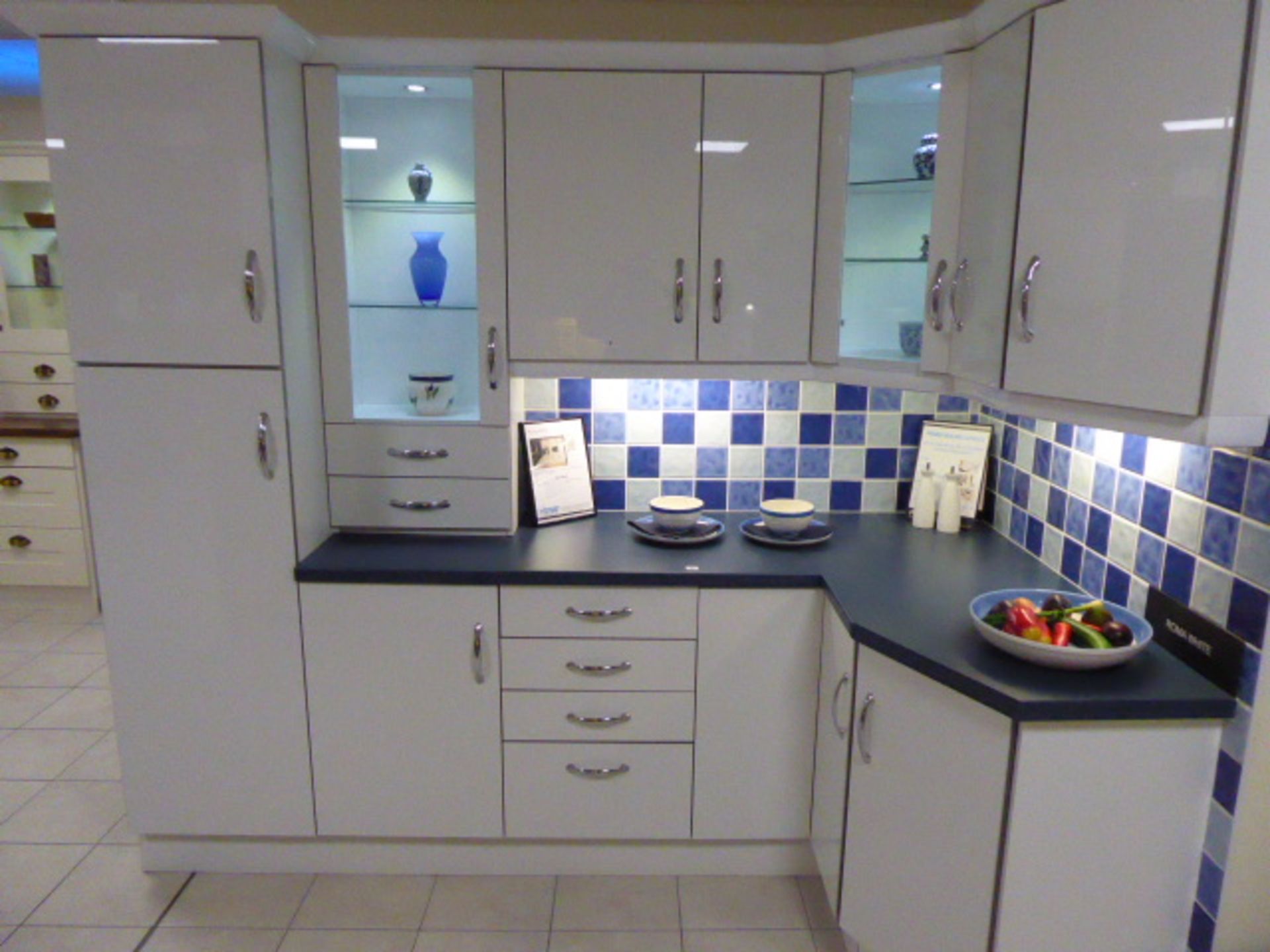 Roma White kitchen in L-shape with a blue granite effect worktop. Max dimensions 240cm by 130cm