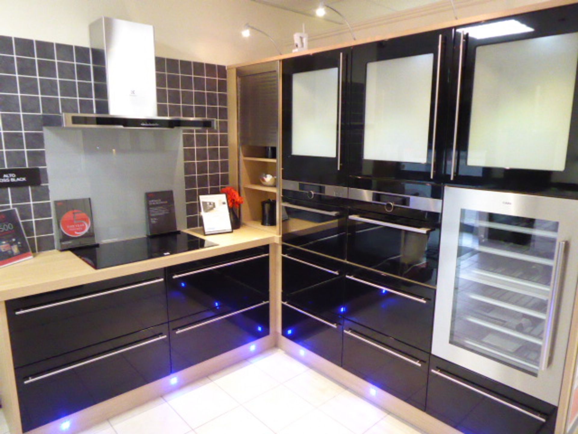 Alto Gloss Black kitchen in corner shape with a light oak effect worktop. Max dimensions 200cm by