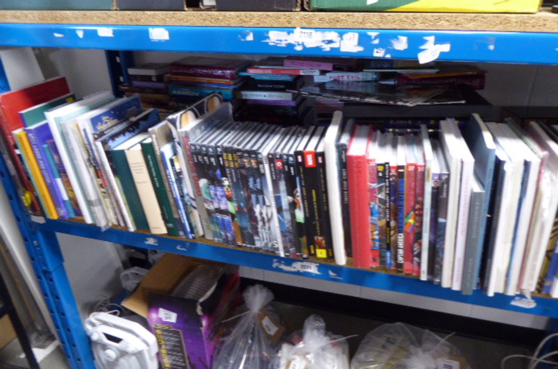 Shelf comprising large selection of Graphic novels, reference material etc