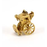 A 9ct yellow gold charm in the form of an articulated carriage,