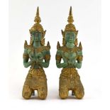 A pair of Far Eastern green patinated and gilt decorated bronze figures modelled as a couple at