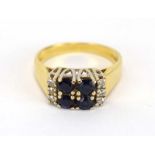 An 18ct yellow gold ring set four small sapphires and six small diamonds in a raised setting,