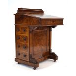 A Victorian walnut davenport, the tooled leather sloped surface over a maple fitted interior,