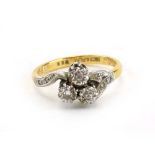 An 18ct yellow gold and platinum highlighted crossover ring set three small diamonds in an illusion
