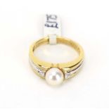 A 9ct two colour gold ring set cultured pearl and two small diamonds, pearl d.