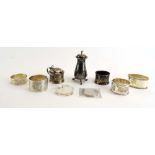 A silver three piece cruet set and four silver napkin rings, various dates and makers,