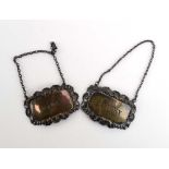 Two silver repousse decorated decanter labels,