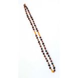 A single strand amber coloured glass bead necklace, l.