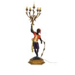 A polychrome and metalwork 'blackamoor' lamp modelled as a young man holding a five-branch foliate