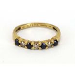 A 9ct yellow gold half eternity ring set four small sapphires interspersed with three diamonds,