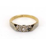 A 9ct yellow gold and platinum highlighted ring set three small diamonds in an illusion setting,