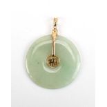 A Chinese yellow metal mounted pale green jade disc pendant, d.