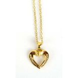 An 18ct yellow gold fine chainlink necklace suspending an openwork heart shaped pendant set small
