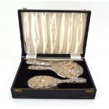 A four piece silver repousse decorated dressing table set, Birmingham 1971,