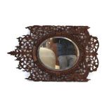 An Eastern carved teak fretwork mirror with an oval plate, h.
