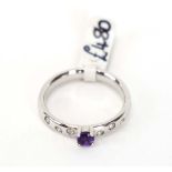 An 18ct white gold ring set small amethyst in a raised setting,