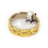 An 18ct two colour gold band ring decorated in the Celtic manner, maker DT, Sheffield 2002, band w.