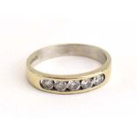 An 18ct white gold ring set five clear stones in a tension channel setting, ring size N,