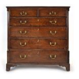 A Georgian oak chest of two short over four long graduated drawers flanked by barrel columns with