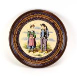 A Quimper bread plate decorated with a traditional couple within a blue and brown wreath border, d.