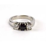An 18ct white gold ring set black diamond and two brilliant cut white diamonds in an inline setting,