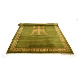 A Kangri Tibetan rug, the green ground decorated with a central symbol and geometric bands,