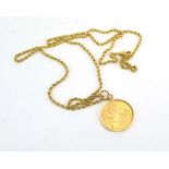 A gold plated necklace suspending a sovereign dated 1957 in a loose mount