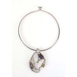 A modern metalware torque necklace suspending an openwork amethyst set pendant CONDITION