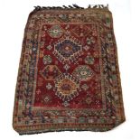 A Caucasian rug, the red ground with blue, salmon and cream motifs, within matching bands,