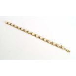 A 10ct yellow gold bracelet set sixteen cultured pearls and small diamonds, l. 17.5 cm, 12.