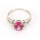 A 14ct white gold ring set oval pink sapphire within a raised setting,